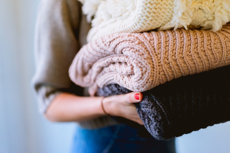 인스 타 그램을위한 가을 사진 아이디어-그녀의 손에 접힌 스웨터를 입은 소녀